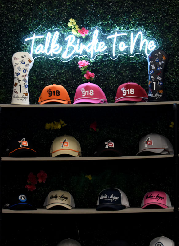 A hat rack with a sign saying Talk Birdie To Me